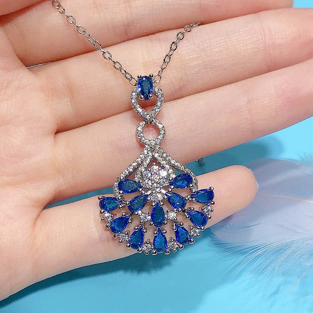 Naszyjnik ze szlachetnymi kamieniami Topaz wisiorek w kolorze niebieskim, ozdobiony diamentami i kryształami. Wykonany z 18-karatowego białego złota - Wianko - 1