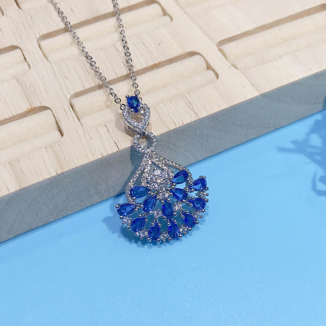 Naszyjnik ze szlachetnymi kamieniami Topaz wisiorek w kolorze niebieskim, ozdobiony diamentami i kryształami. Wykonany z 18-karatowego białego złota - Wianko - 10