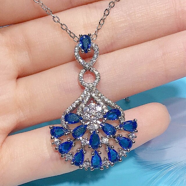 Naszyjnik ze szlachetnymi kamieniami Topaz wisiorek w kolorze niebieskim, ozdobiony diamentami i kryształami. Wykonany z 18-karatowego białego złota - Wianko - 18