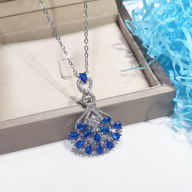 Naszyjnik ze szlachetnymi kamieniami Topaz wisiorek w kolorze niebieskim, ozdobiony diamentami i kryształami. Wykonany z 18-karatowego białego złota - Wianko - 4