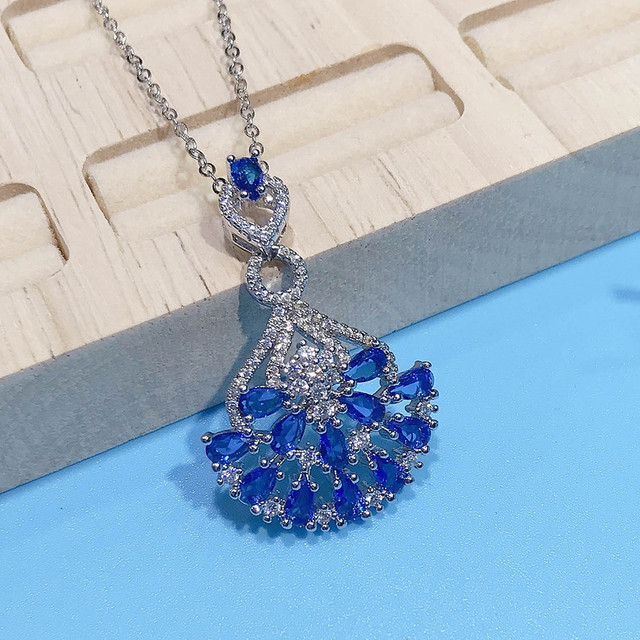 Naszyjnik ze szlachetnymi kamieniami Topaz wisiorek w kolorze niebieskim, ozdobiony diamentami i kryształami. Wykonany z 18-karatowego białego złota - Wianko - 17