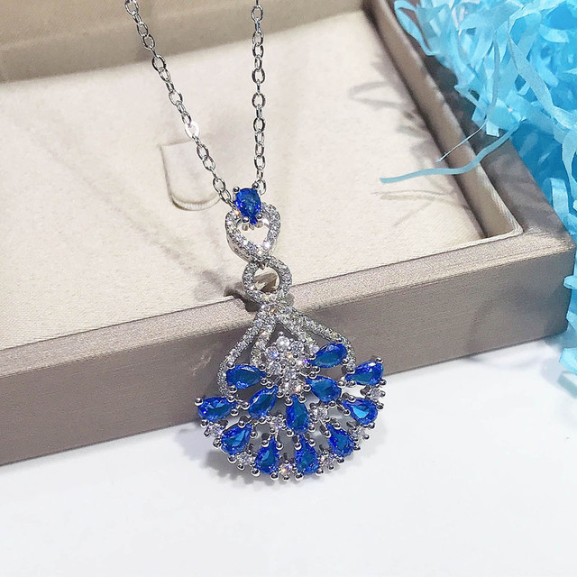 Naszyjnik ze szlachetnymi kamieniami Topaz wisiorek w kolorze niebieskim, ozdobiony diamentami i kryształami. Wykonany z 18-karatowego białego złota - Wianko - 14