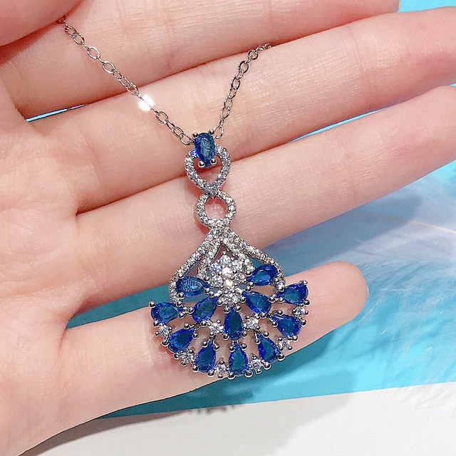 Naszyjnik ze szlachetnymi kamieniami Topaz wisiorek w kolorze niebieskim, ozdobiony diamentami i kryształami. Wykonany z 18-karatowego białego złota - Wianko - 13