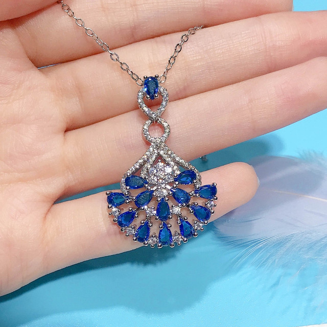 Naszyjnik ze szlachetnymi kamieniami Topaz wisiorek w kolorze niebieskim, ozdobiony diamentami i kryształami. Wykonany z 18-karatowego białego złota - Wianko - 8